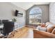 Bright home office area with large window, hardwood floors, and comfortable seating at 7141 S Versailles St, Aurora, CO 80016