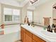 Bright bathroom boasts dual sinks, soaking tub and large window with natural light at 11556 W Cooper Pl, Littleton, CO 80127