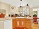 Functional kitchen with wood cabinets, island with seating, and open view to the living space at 11556 W Cooper Pl, Littleton, CO 80127