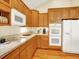 Well-lit kitchen with white appliances, ample cabinet space and tile countertops at 11556 W Cooper Pl, Littleton, CO 80127