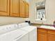 Laundry room featuring front-loading washer and dryer, ample cabinet space, and a utility sink at 11556 W Cooper Pl, Littleton, CO 80127
