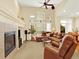Bright living room featuring a fireplace, ceiling fan, and large windows with lots of light at 11556 W Cooper Pl, Littleton, CO 80127