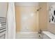 Standard bathtub and shower featuring chrome shower head with bright neutral tiling at 7740 W 35Th Ave # 210, Wheat Ridge, CO 80033
