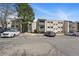 Exterior view of condominium buildings with parking spaces and mature trees at 7740 W 35Th Ave # 210, Wheat Ridge, CO 80033