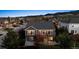 Aerial view of a house surrounded by green trees with mountains in the distance at dusk at 8312 Hackamore Rd, Littleton, CO 80125