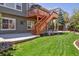 Lawn and stone patio featuring a staircase to upper deck is perfect for entertaining or relaxing at 8312 Hackamore Rd, Littleton, CO 80125