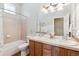 Bathroom with double sink, tub, shower and oak vanity with great mirror at 8312 Hackamore Rd, Littleton, CO 80125