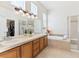 Bright bathroom featuring dual sinks, a soaking tub, and a glass-enclosed shower at 8312 Hackamore Rd, Littleton, CO 80125