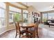 Charming breakfast nook features a round wooden table set by large windows, plus a fireplace and living room area at 8312 Hackamore Rd, Littleton, CO 80125