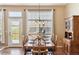 Inviting dining room with a wooden table set for six, complemented by natural light and access to the outdoor deck at 8312 Hackamore Rd, Littleton, CO 80125