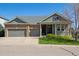 Beautiful home with a brick facade, well-maintained lawn, and an attached three car garage at 8312 Hackamore Rd, Littleton, CO 80125