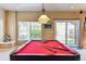 Inviting game room featuring a red pool table with overhead lighting and a large window with backyard view at 8312 Hackamore Rd, Littleton, CO 80125