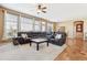 Spacious living room with a large sectional sofa, big windows, ceiling fan and neutral decor, seamlessly connected to dining area at 8312 Hackamore Rd, Littleton, CO 80125