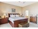 Comfortable main bedroom features a king bed, wood furniture, and ensuite bathroom access at 8312 Hackamore Rd, Littleton, CO 80125