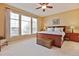 Spacious main bedroom with large windows, neutral carpeting, and a ceiling fan at 8312 Hackamore Rd, Littleton, CO 80125