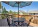 Outdoor wooden deck featuring a grill, patio furniture with umbrella is perfect for relaxing and outdoor cooking at 8312 Hackamore Rd, Littleton, CO 80125