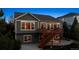 Beautiful rear exterior with a wooden deck and stairs to the patio, perfect for outdoor entertaining at 8312 Hackamore Rd, Littleton, CO 80125