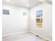 Sunlit bedroom with neutral walls, white trim, and large windows offering neighborhood views at 779 N Tempe St, Aurora, CO 80018
