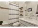 Clean bathroom with a shower-tub combo, white tile, decorative shelves, and a modern sink and vanity at 328 Simmental Loop, Castle Rock, CO 80104