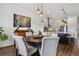 Open dining area showcasing wood floors, a modern light fixture, and kitchen in the background at 328 Simmental Loop, Castle Rock, CO 80104