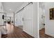 Bright hallway with barn doors, wood floors, and access to multiple rooms, creating an inviting atmosphere at 328 Simmental Loop, Castle Rock, CO 80104