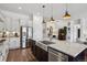 Gourmet kitchen island with a stainless steel sink, granite counters, and modern lighting at 328 Simmental Loop, Castle Rock, CO 80104
