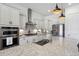 Bright, well-appointed kitchen featuring white cabinets, stainless appliances, and modern lighting at 328 Simmental Loop, Castle Rock, CO 80104