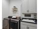 Modern laundry room with sleek appliances, utility sink, and ample cabinet storage at 328 Simmental Loop, Castle Rock, CO 80104