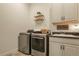 Well-equipped laundry room with modern washer and dryer, cabinets, and sink at 328 Simmental Loop, Castle Rock, CO 80104