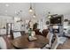 Open-concept living space with a stone fireplace, ceiling fan, and modern lighting over the island at 328 Simmental Loop, Castle Rock, CO 80104