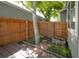 Cozy fenced-in backyard space with a deck, landscaping, and a young tree providing shade and privacy at 5190 Buckingham Rd, Boulder, CO 80301
