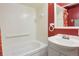 Updated bathroom featuring a soaking tub, tiled walls, vanity, and bright red accent wall at 5190 Buckingham Rd, Boulder, CO 80301