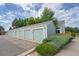 Detached garages with light blue doors are lined up with mature landscaping, showing convenience and storage at 5190 Buckingham Rd, Boulder, CO 80301