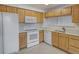 Well-lit kitchen featuring white appliances, modern countertops, and bright wooden cabinets at 5190 Buckingham Rd, Boulder, CO 80301