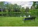 Serene pond view with surrounding trees and a bench, offering a peaceful retreat within the community at 5190 Buckingham Rd, Boulder, CO 80301