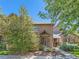 Inviting brick townhome with a covered entrance, surrounded by mature trees and well-maintained landscaping at 3540 E 5Th Ave, Denver, CO 80206
