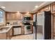 Well-equipped kitchen featuring stainless steel appliances, stone countertops, and wooden cabinetry at 3540 E 5Th Ave, Denver, CO 80206