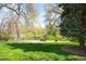 Large grassy backyard with mature trees and landscaping offering a peaceful outdoor space at 2213 E Panama Dr, Centennial, CO 80121