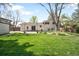 Large backyard with mature trees, lush lawn, and patio space, perfect for outdoor enjoyment at 2213 E Panama Dr, Centennial, CO 80121