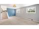Open living room with a staircase, neutral carpet, and ample natural light from multiple windows at 2213 E Panama Dr, Centennial, CO 80121