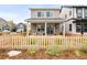Charming two-story home features a cozy front porch with rocking chairs and a welcoming picket fence at 129 Mesa Way, Superior, CO 80027