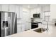 Well-lit kitchen with modern stainless steel appliances, white cabinets, and efficient countertop space at 129 Mesa Way, Superior, CO 80027