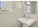 Well-lit bathroom featuring a pedestal sink, neutral walls and a framed mirror at 1273 S Dallas Ct, Denver, CO 80247