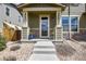 Inviting entrance to home, with flower pots on porch, rock landscaping and concrete stairs at 1273 S Dallas Ct, Denver, CO 80247