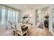 Bright dining area with a wooden table set for six, complemented by stylish curtains and natural light at 4875 E 148Th Pl, Thornton, CO 80602