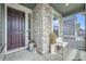Cozy front porch with stone columns, decorative planters, and a seating area with decorative furniture at 4875 E 148Th Pl, Thornton, CO 80602