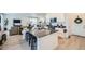 Bright and open kitchen with a center island, barstool seating, and views into the living area at 4875 E 148Th Pl, Thornton, CO 80602