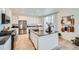Modern kitchen features white cabinets, black countertops, an island with seating, and stainless steel appliances at 4875 E 148Th Pl, Thornton, CO 80602