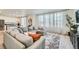 Living room featuring a large sectional sofa, sheer curtains, and adjacent view of the kitchen at 4875 E 148Th Pl, Thornton, CO 80602