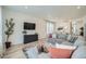 Bright living room featuring a comfortable gray sectional sofa and a modern entertainment center at 4875 E 148Th Pl, Thornton, CO 80602